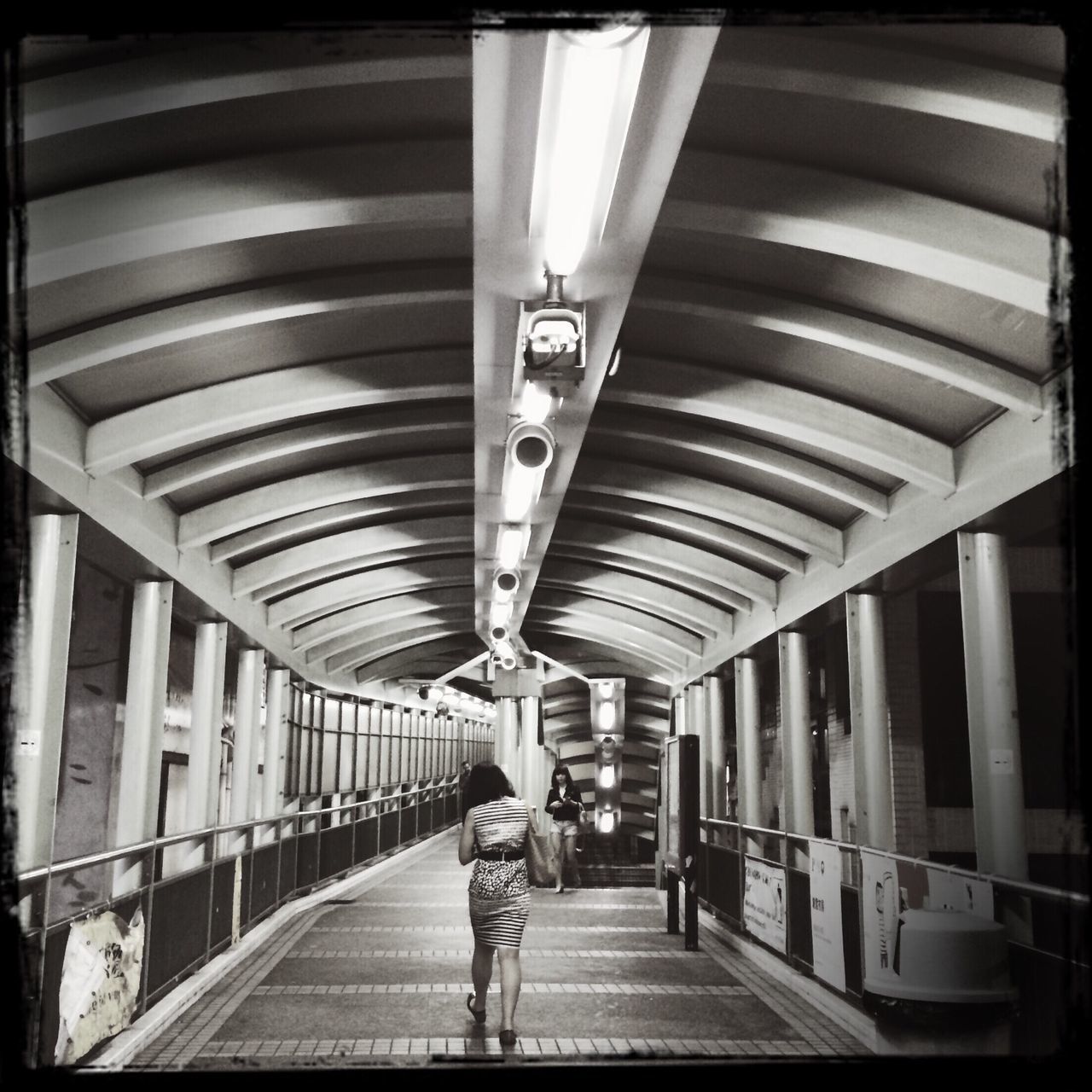 architecture, built structure, indoors, ceiling, the way forward, transportation, walking, men, illuminated, incidental people, diminishing perspective, railroad station, railing, corridor, full length, lighting equipment, city, building exterior