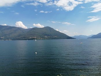 Scenic view of sea and mountains against blue sky
