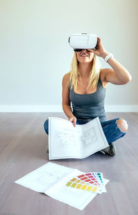 Woman wearing virtual reality simulator while sitting at home