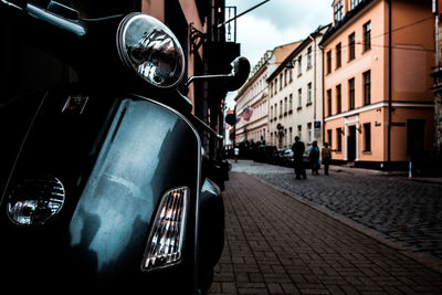 Close-up of motor scooter on street in city