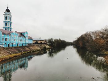 Scenic view of lake by buildings against sky