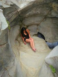 Full length of woman sitting on rock formation