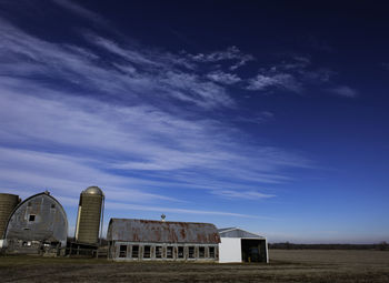 Abandoned building in field against sky