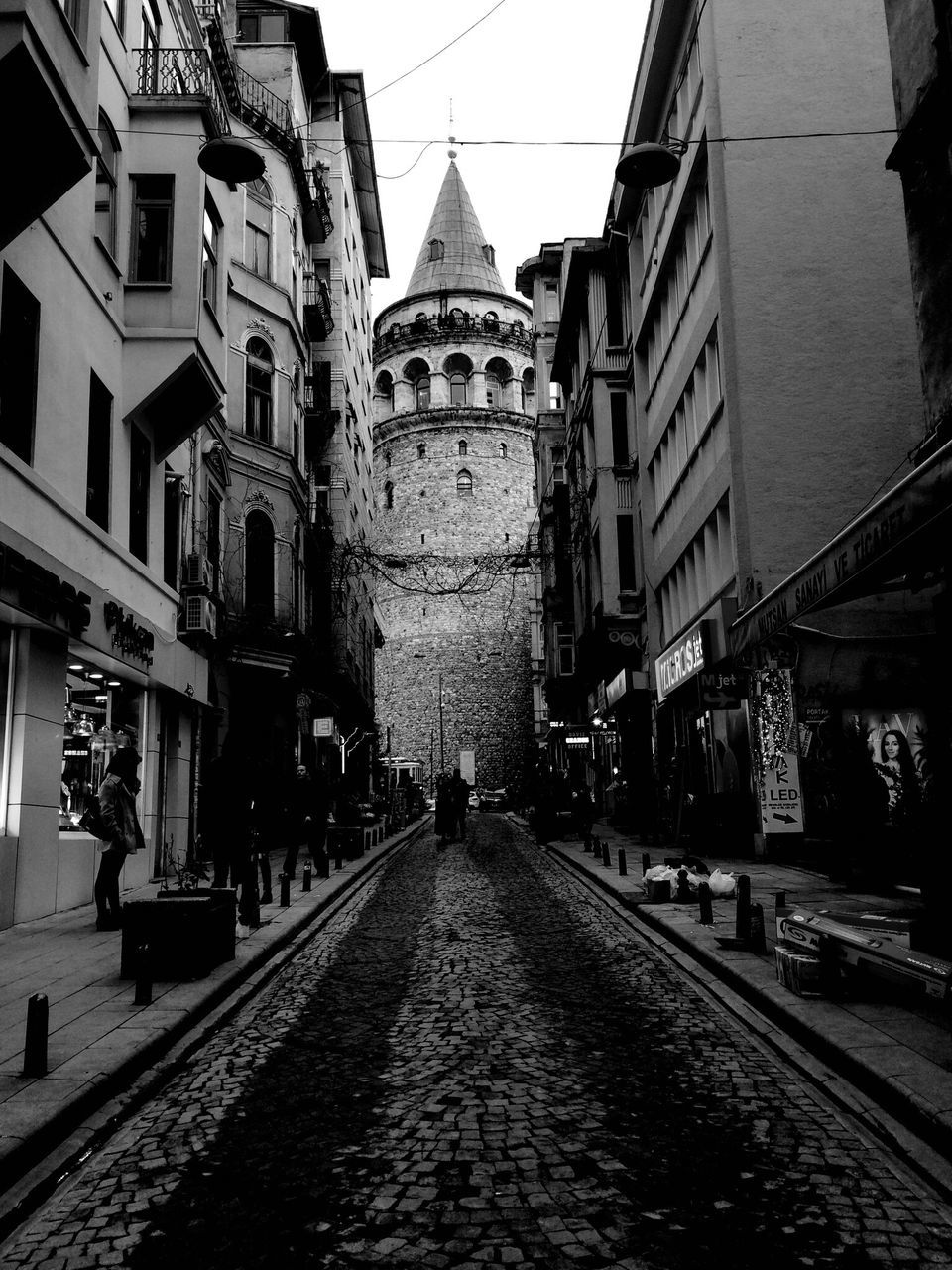 architecture, building exterior, built structure, street, the way forward, cobblestone, road, long, incidental people, city, day, outdoors, sky, in front of, city life, facade, surface level