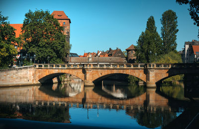 Arch bridge over river against sky