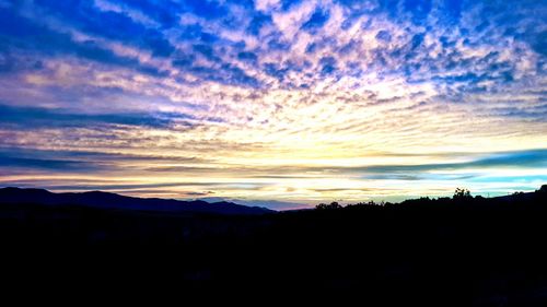 Scenic view of silhouette mountains against sky at sunset