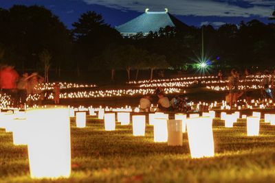Illuminated cemetery against sky at night