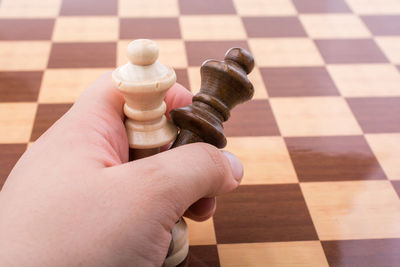 Cropped hands of person holding chess pieces