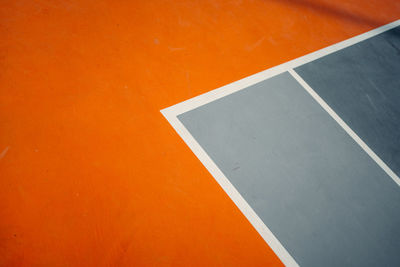 High angle view of empty chair against orange wall