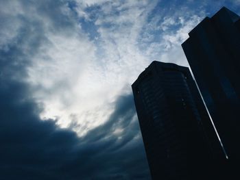 Low angle view of buildings against cloudy sky