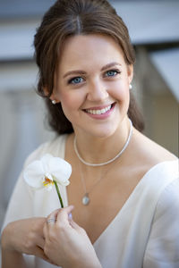 Portrait of young woman holding flower