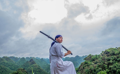 Man standing on mountain against sky