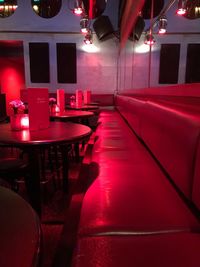 Empty chairs and tables in illuminated restaurant