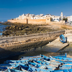 Boats moored in sea against buildings