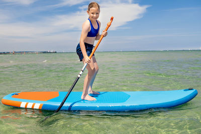 Boy in sea against sky