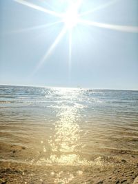 Scenic view of sea against bright sun