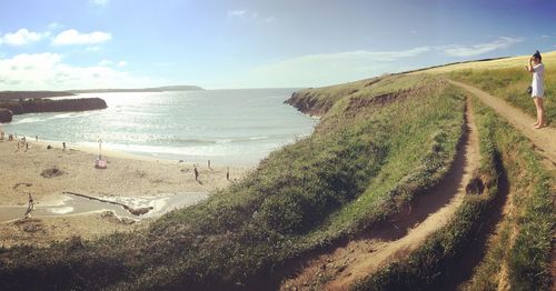 Woman standing on hill by beach