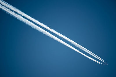 Low angle view of vapor trail against blue sky