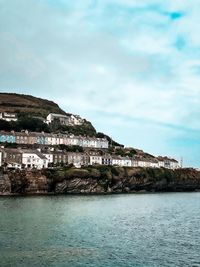 Scenic view of sea by buildings against sky