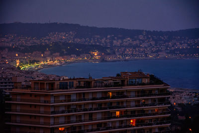 High angle view of illuminated buildings against sky at night