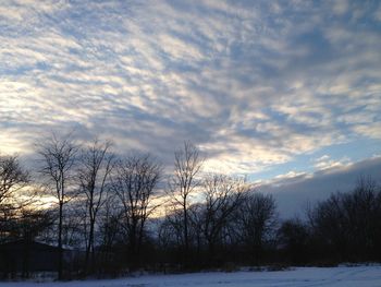 Snow covered landscape against cloudy sky