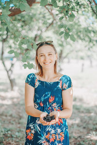 Beautiful caucasian woman with handful of mulberries at farm. farm harvest gathering 