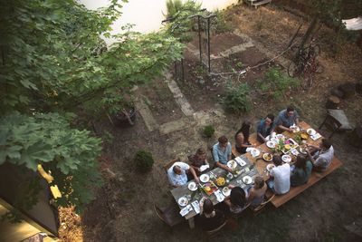 High angle view of people having food at table in yard