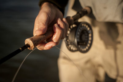 Cropped image of man holding fishing rod