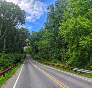 Lonely road disappearing into happy sky