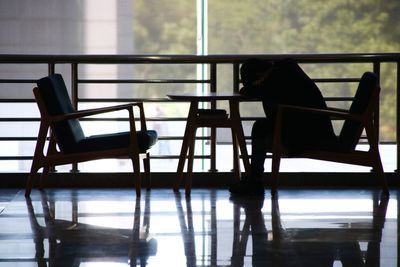 Empty chairs and tables in glass window