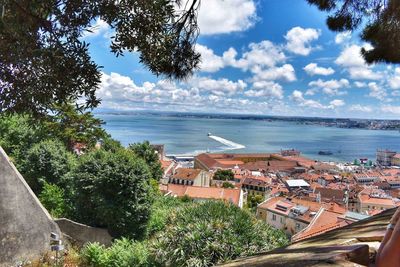 Scenic view of sea by town against sky