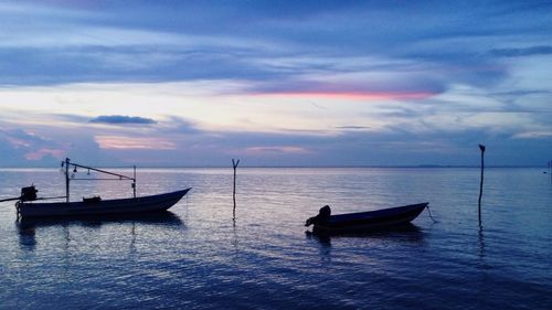 Silhouette boat in sea against sky during sunset