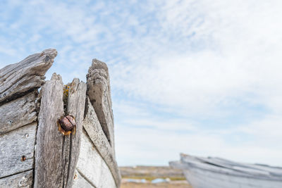 Close-up of abandoned boat against sky