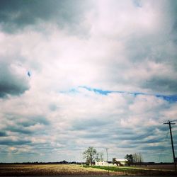 Scenic view of field against cloudy sky