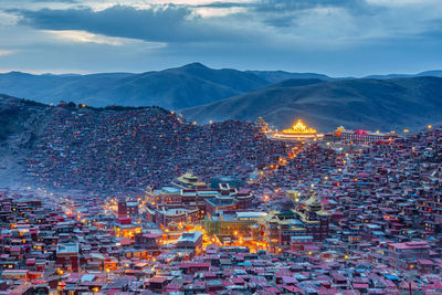 High angle view of illuminated cityscape against sky at dusk