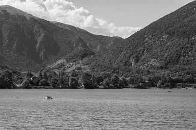 Scenic view of lake by mountains against sky