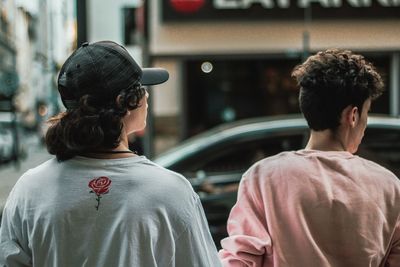 Rear view of friends on street in city