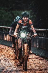 Portrait of man riding bicycle in muddy road