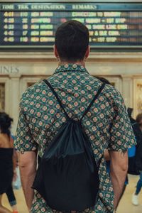 Rear view of man with backpack standing at airport