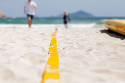 Close-up of yellow water on beach against sky