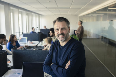 Portrait of team leader standing in office