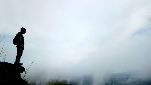 Low angle view of man standing against sky