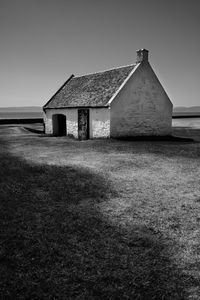 House on field against clear sky