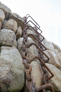 Low angle view of rusty stack against sky