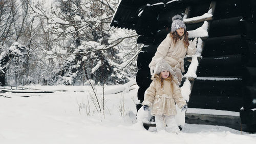 Winter portrait. pretty little girls, dressed in warm winter clothes, fully covered with snowflakes