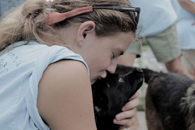 Close-up of woman kissing dog