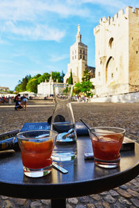 View of drink on table against buildings in city