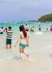 Women enjoying at beach against sky