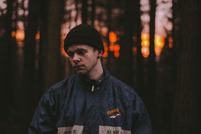 Portrait of young man looking away in forest