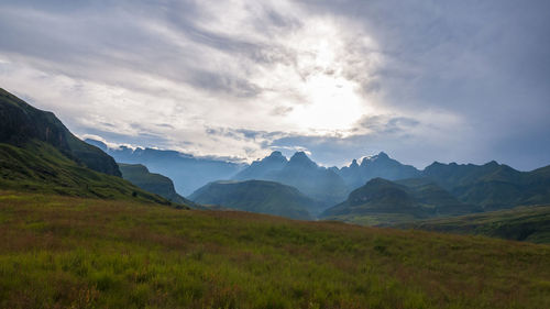 Scenic view of field and mountains against sky